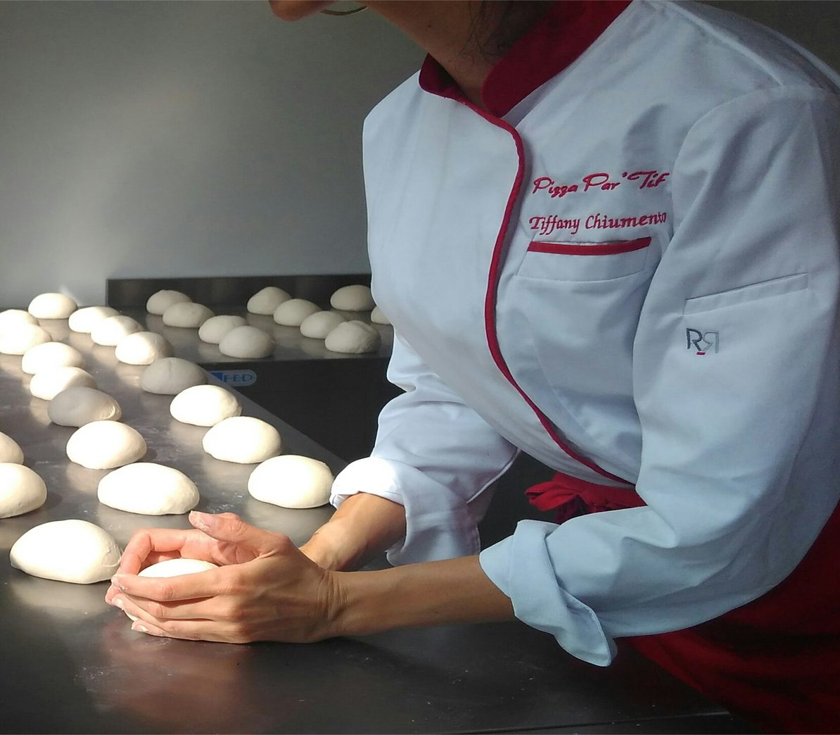 Tiffany Chiumento boule les pâtons dans le laboratoire, devant les rangées de pâtons en repos